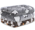 Soft flannel pet blankets folded and stacked in grey, white and brown heart patterns